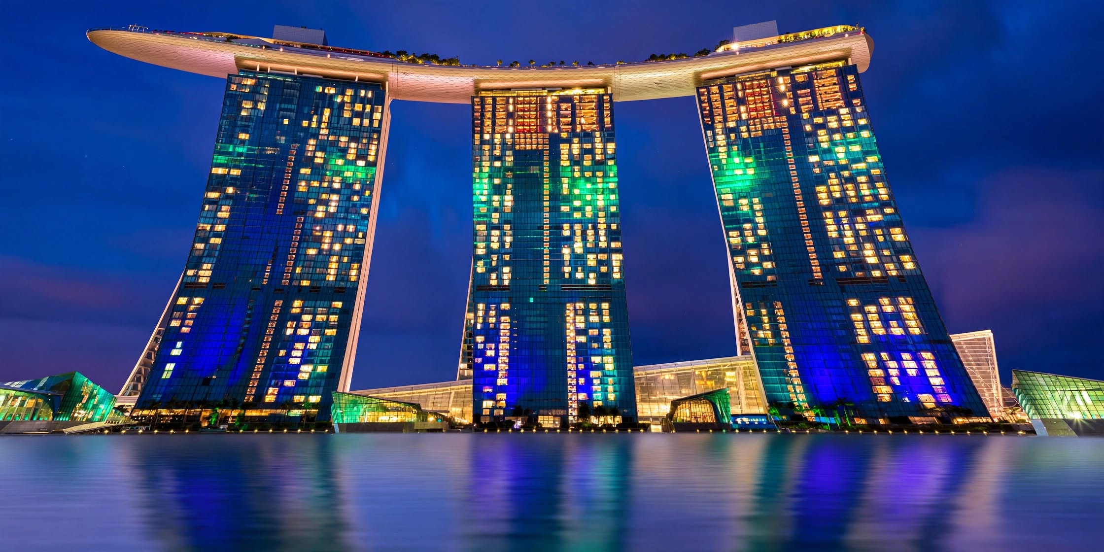 Curved bronze architectural tower of Wynn Las Vegas surrounded by landscaped gardens
